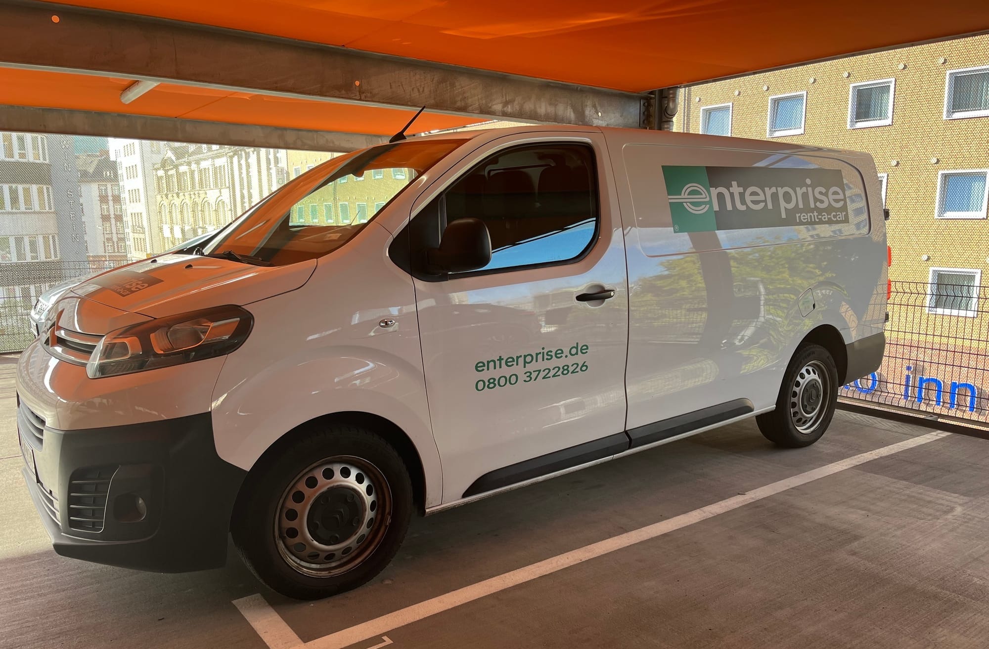 White "commercial light" moving van with an Enterprise logo across the side of it. Taken in a parking garage in Frankfurt.